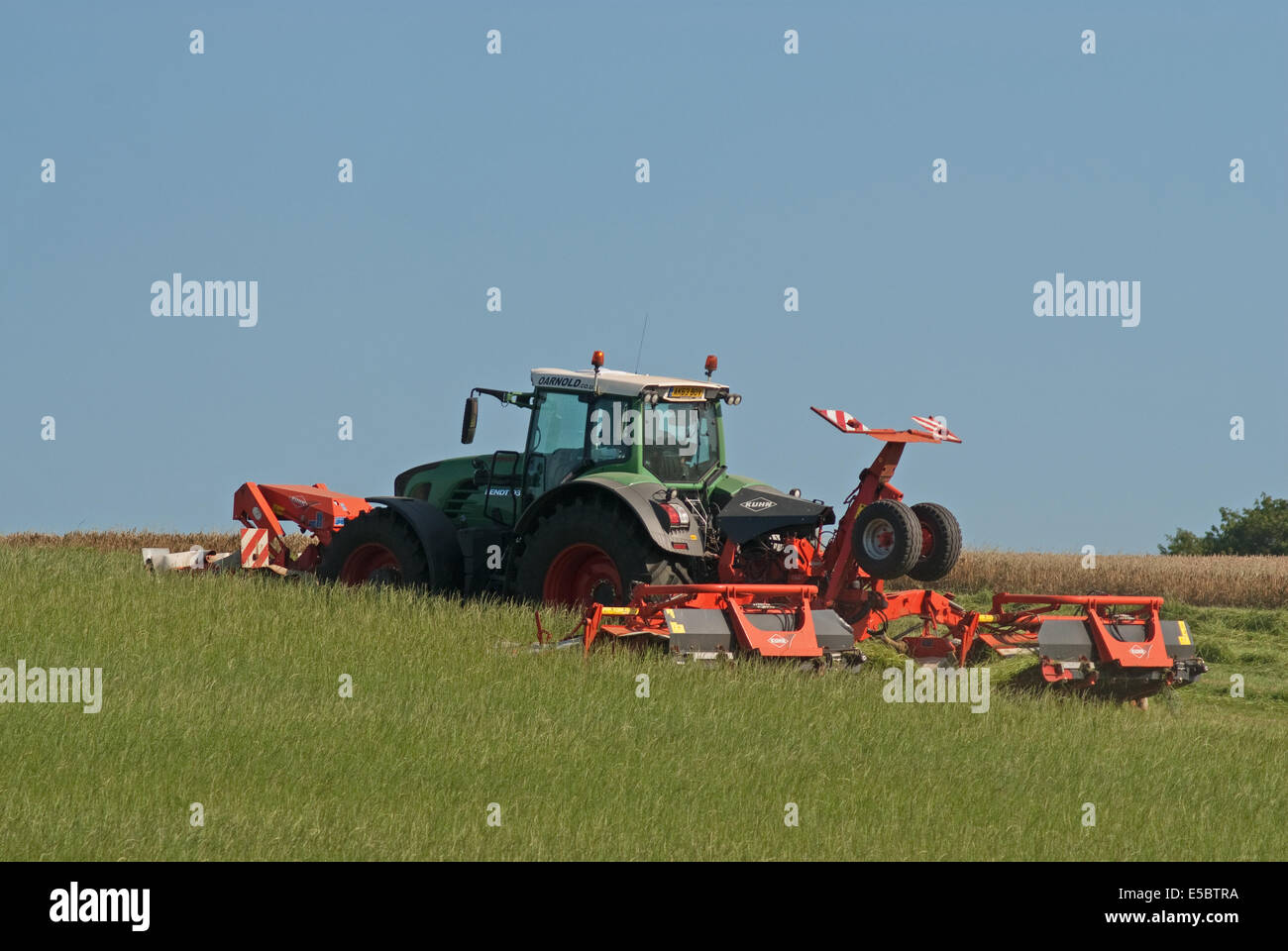 Traktor zieht Grass-Cutter schneiden Rasen für die Herstellung von Heu Stockfoto