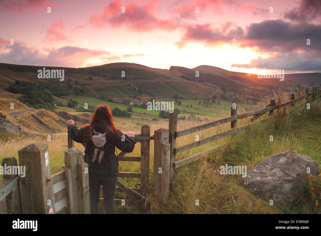 Peak District, Derbyshire, UK. 27. Juli 2014. Ein Frühaufsteher hält an den Hängen des Mam Tor in der Nähe von Castleton wie peachy Sonnenaufgang Wolken Kitings über Hope Valley im Peak District National Park an einem feinen, luftigen Morgen beleuchtet. Die letzten warme Wetter dürfte weiterhin mit variabler Wolke, Duschen und längere Perioden der Regen Auswirkungen auf Teile des Vereinigten Königreichs in Nationalparks-Woche, die beginnt morgen (Mo 28. Juli) und läuft bis zum 3 August Sonne.  1951 wurde der Peak District Großbritanniens erster Nationalpark. Bildnachweis: Matthew Taylor/Alamy Live-Nachrichten Stockfoto