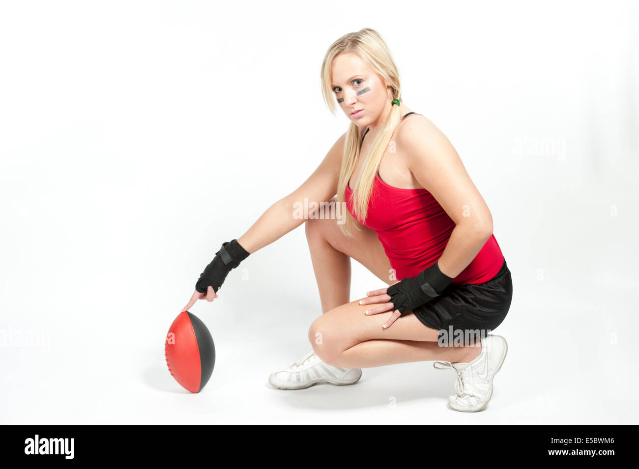 Eine junge Modell tragen einen roten Top und schwarze Shorts Einstellung der Fußballs für einen Kick. Stockfoto