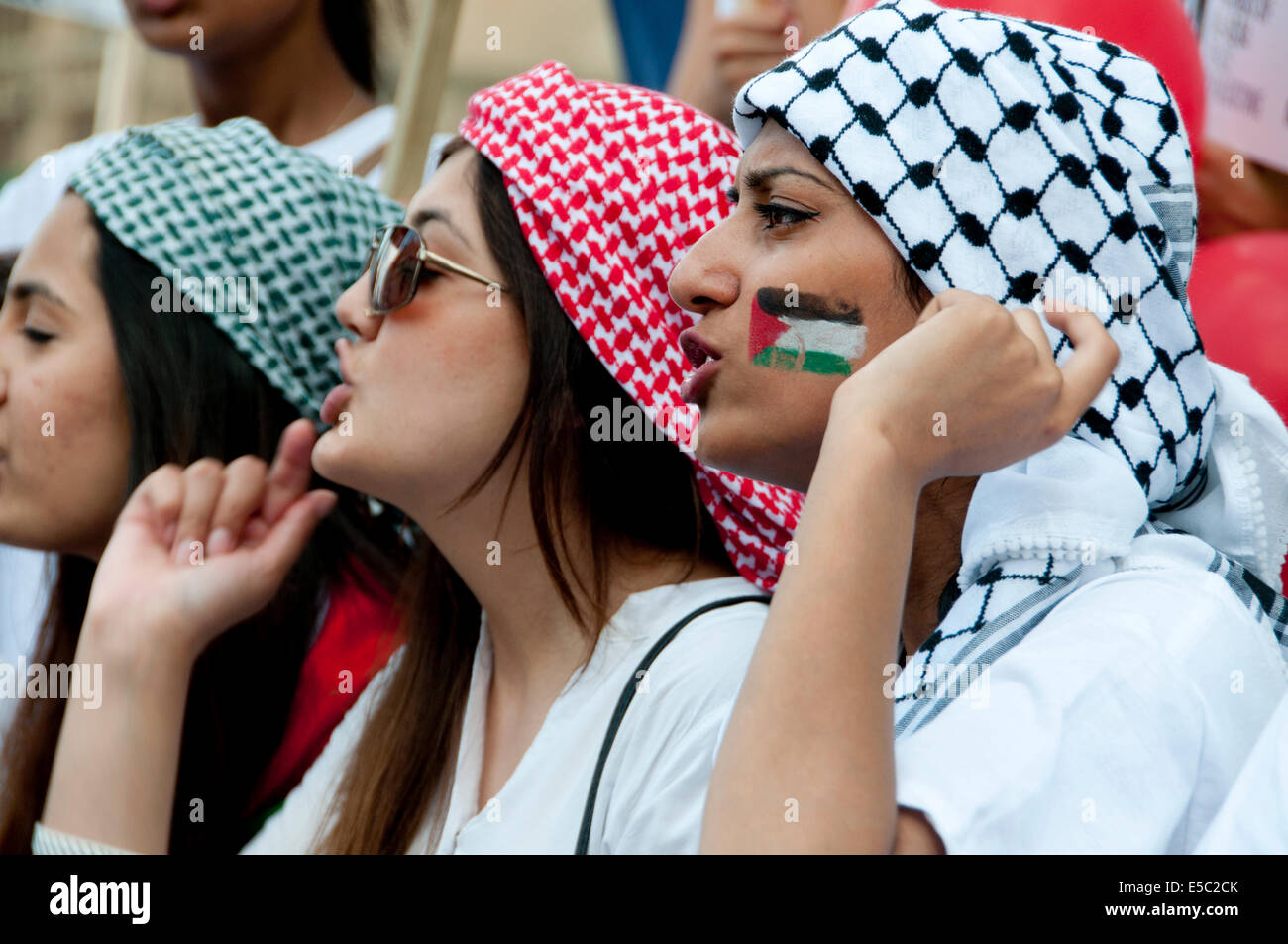 Demonstration gegen die israelische Bombardierung des Gazastreifens, 26.07.2014. Junge Frauen schreien, eine palästinensische Fahne auf ihrem Gesicht gemalt hat. Stockfoto