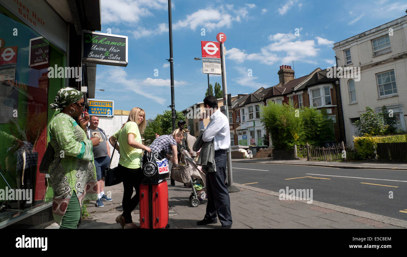 Menschen warten auf einen Bus an der Bushaltestelle Philip Lane im Sommer Tottenham, London N15 England UK KATHY DEWITT Stockfoto