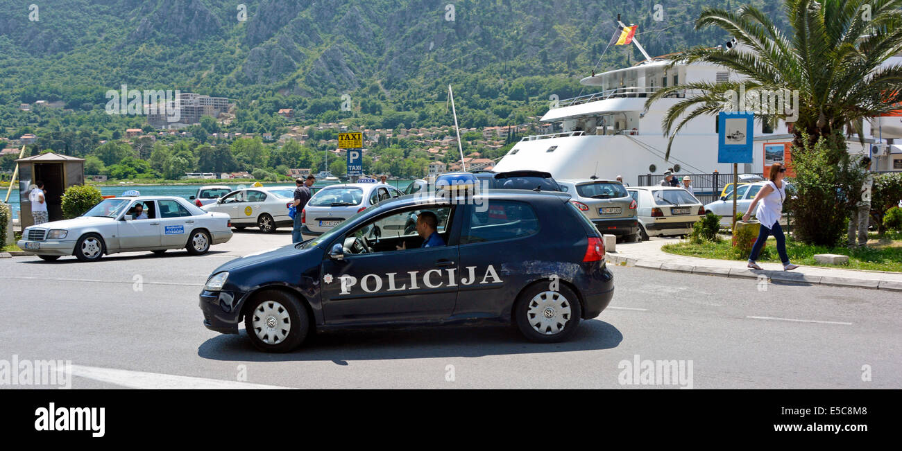 Policija Car & Officers patrouillieren die Kreuzfahrt Schiff Ankunft Bereich & Taxi-Rang Parkplatz am Kotor Hafen & Hafen Montenegro Europa Stockfoto