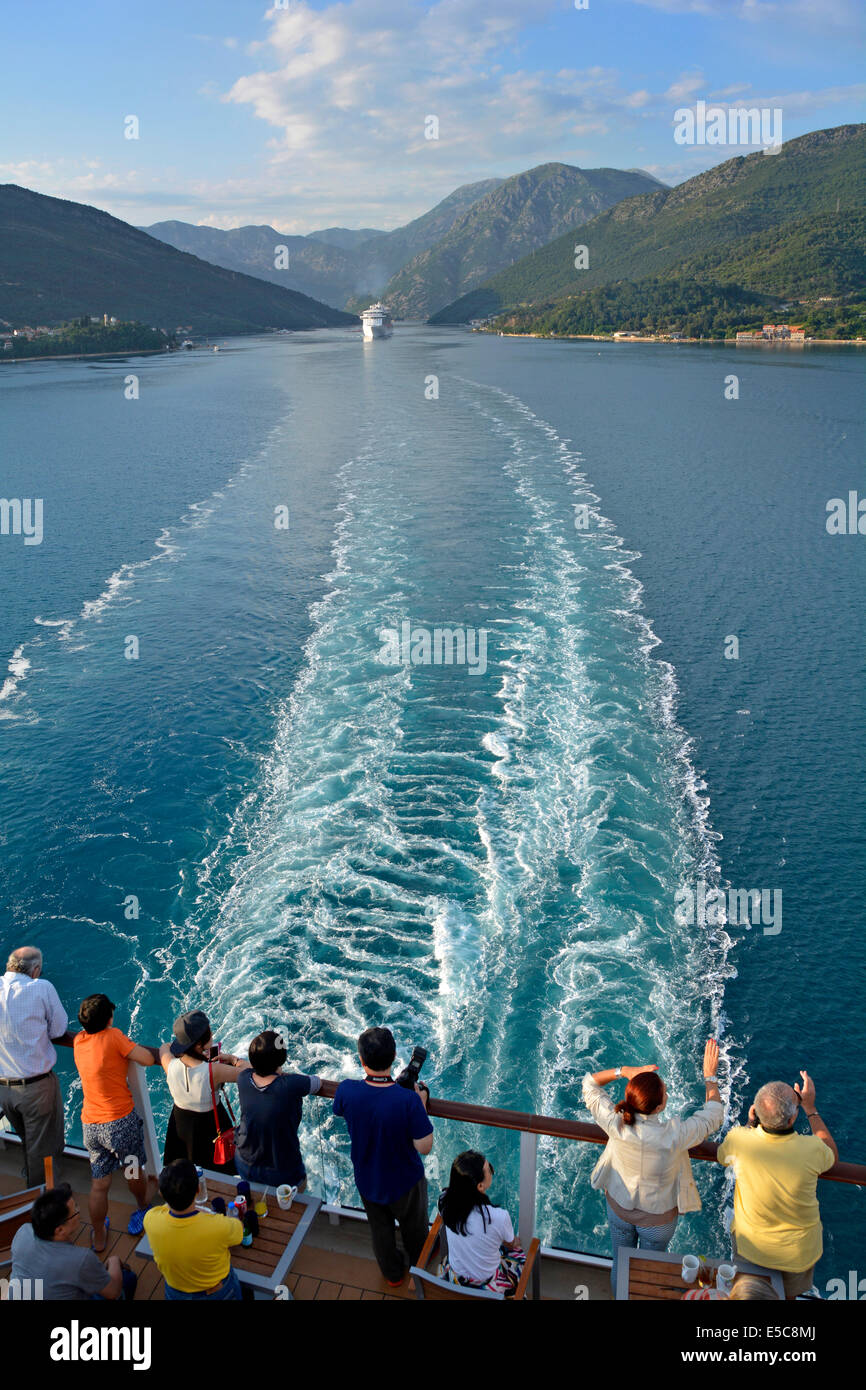Stern von Kreuzfahrtschiff Linienpassagiere sehen Schiffe Wake & Landschaft von Verige Strait in Kotor Bay Montenegro mit einem anderen Kreuzfahrtschiff folgen Stockfoto