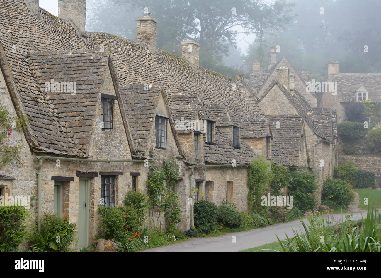 Die Arlington Row, Honig farbigen Weber Cottages im Morgennebel in der Stadt von Bibury in Gloucestershire in den Cotswolds. Stockfoto