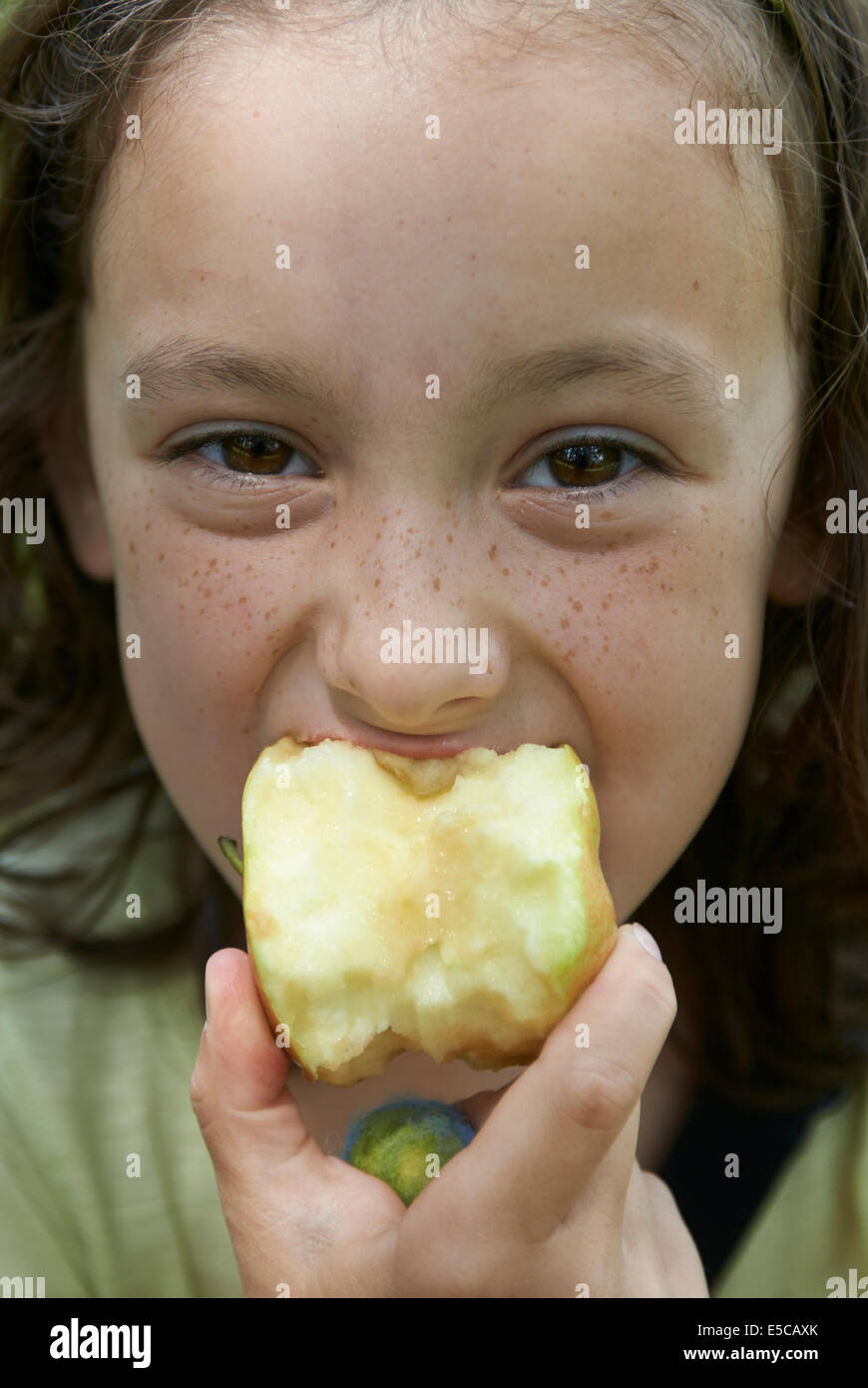 Kind Mädchen essen Apfel, draußen, Porträt, Blickkontakt Stockfoto