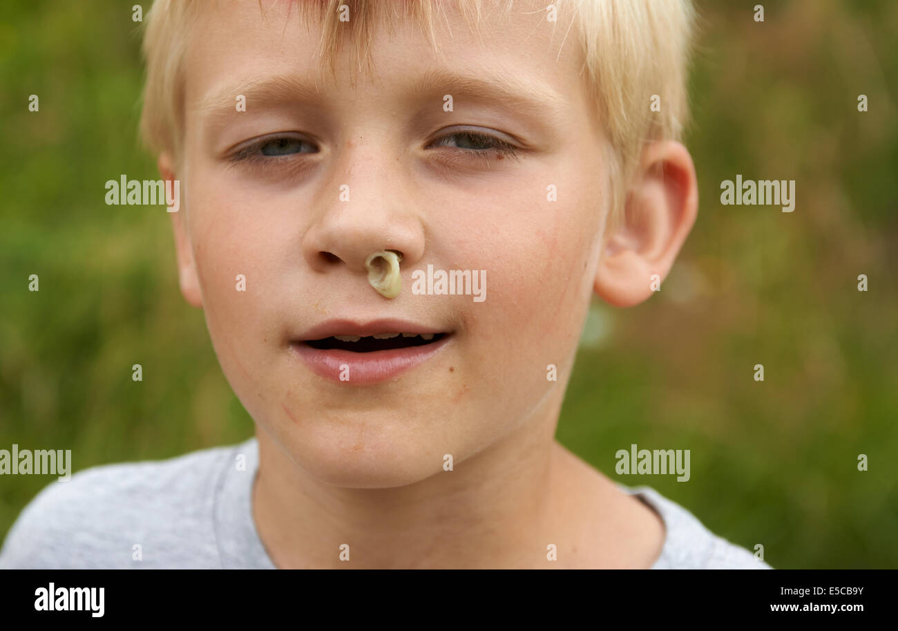 Kind blonde junge mit RHINITIS ohne Gewebe fließt aus der Nase, Porträt, Kopfschuss, Gesicht, detail Stockfoto