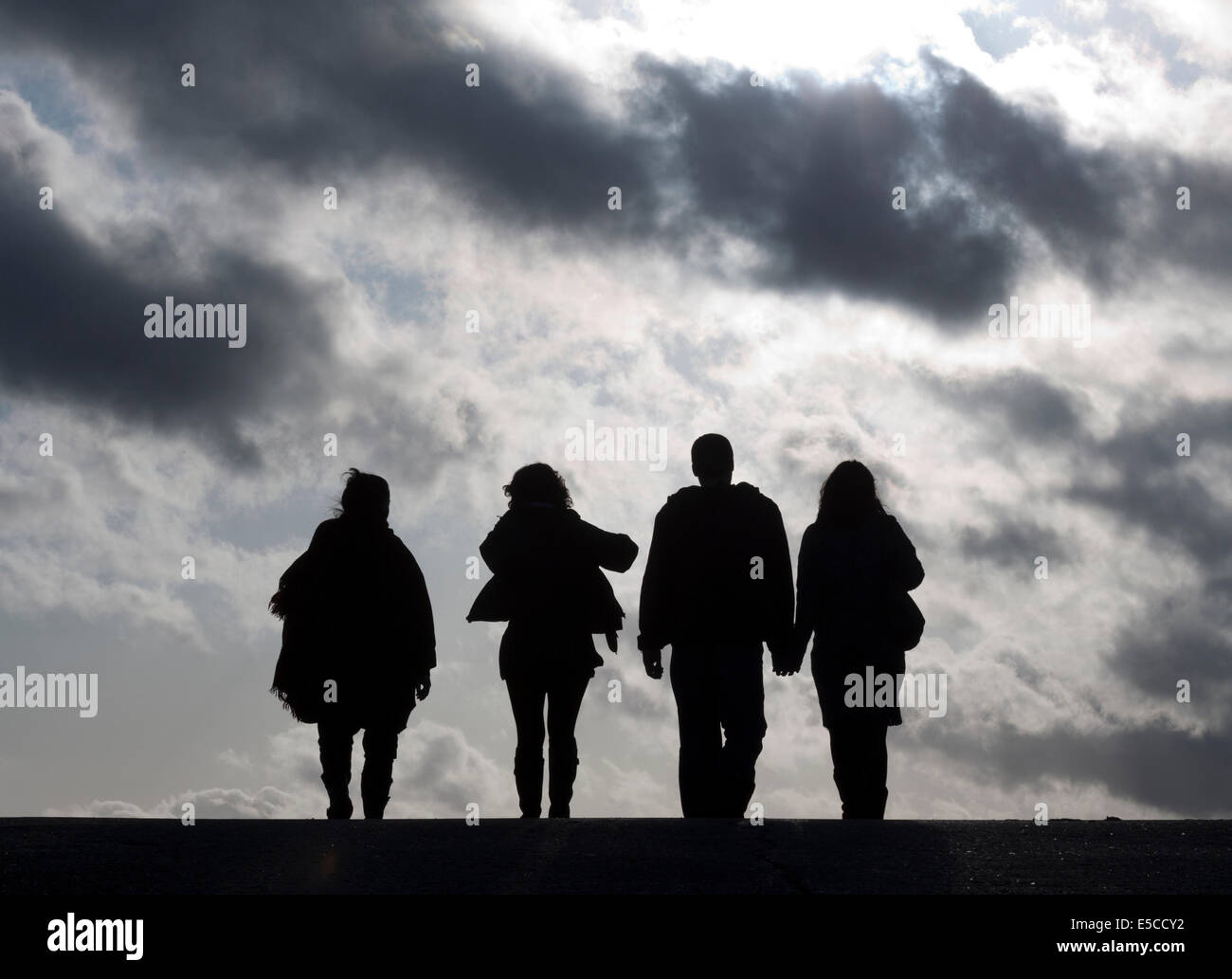 Vier Silhouette Menschen gehen in die Wolken Stockfoto