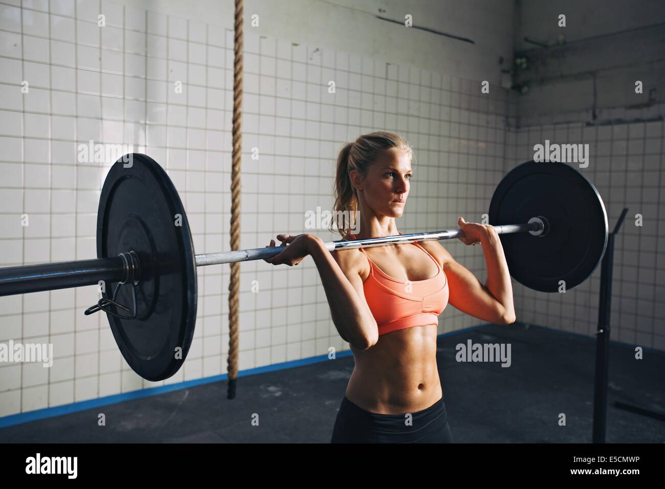 Fitness-Frau konzentriert sich beim Heben der Hanteln. Starke Frau im Crossfit Gym Gewichte zu heben. Kaukasische weibliches Modell mit mu Stockfoto