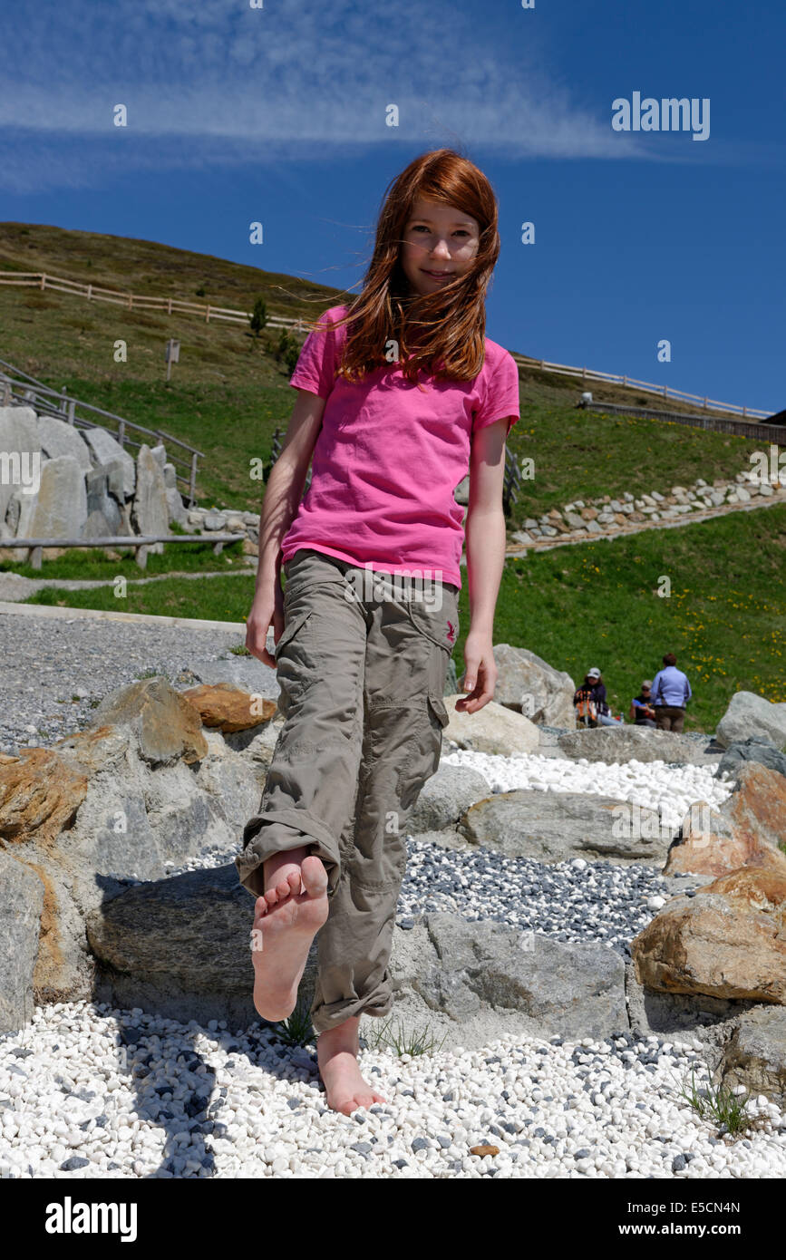 Mädchen auf dem Barfußweg am Watles Abenteuer Berg, in der Nähe von Mals, Vinschgau, Südtirol, Italien Stockfoto