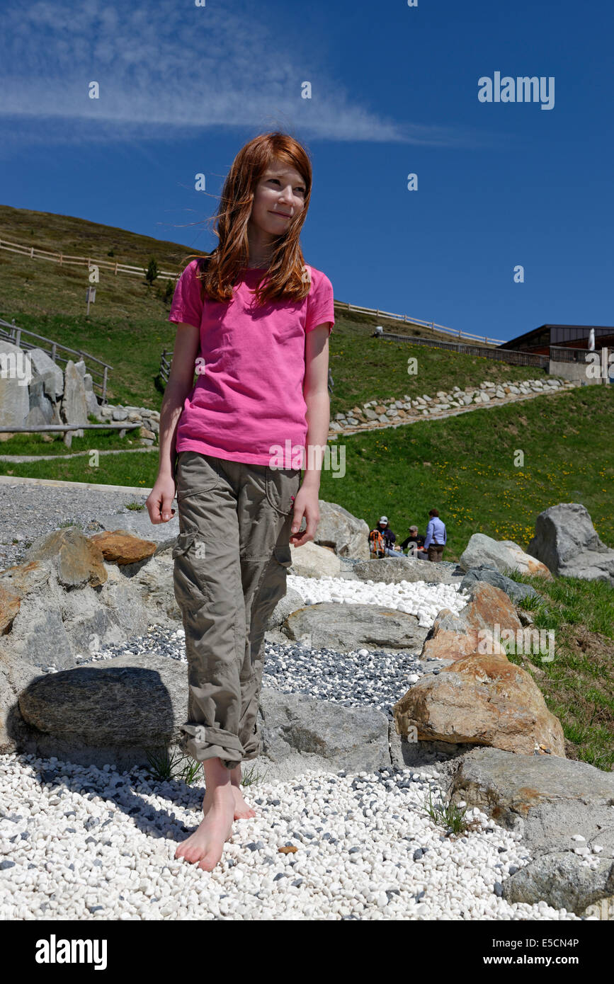 Mädchen auf dem Barfußweg am Watles Abenteuer Berg, in der Nähe von Mals, Vinschgau, Südtirol, Italien Stockfoto