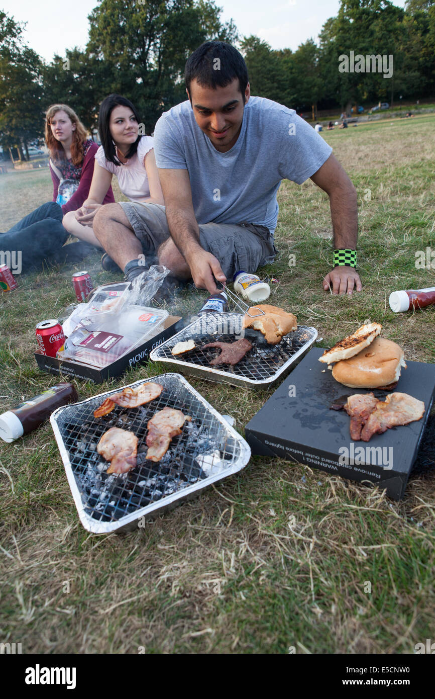 Freunde kochen auf einem Einweg-Grill in einem park Stockfoto