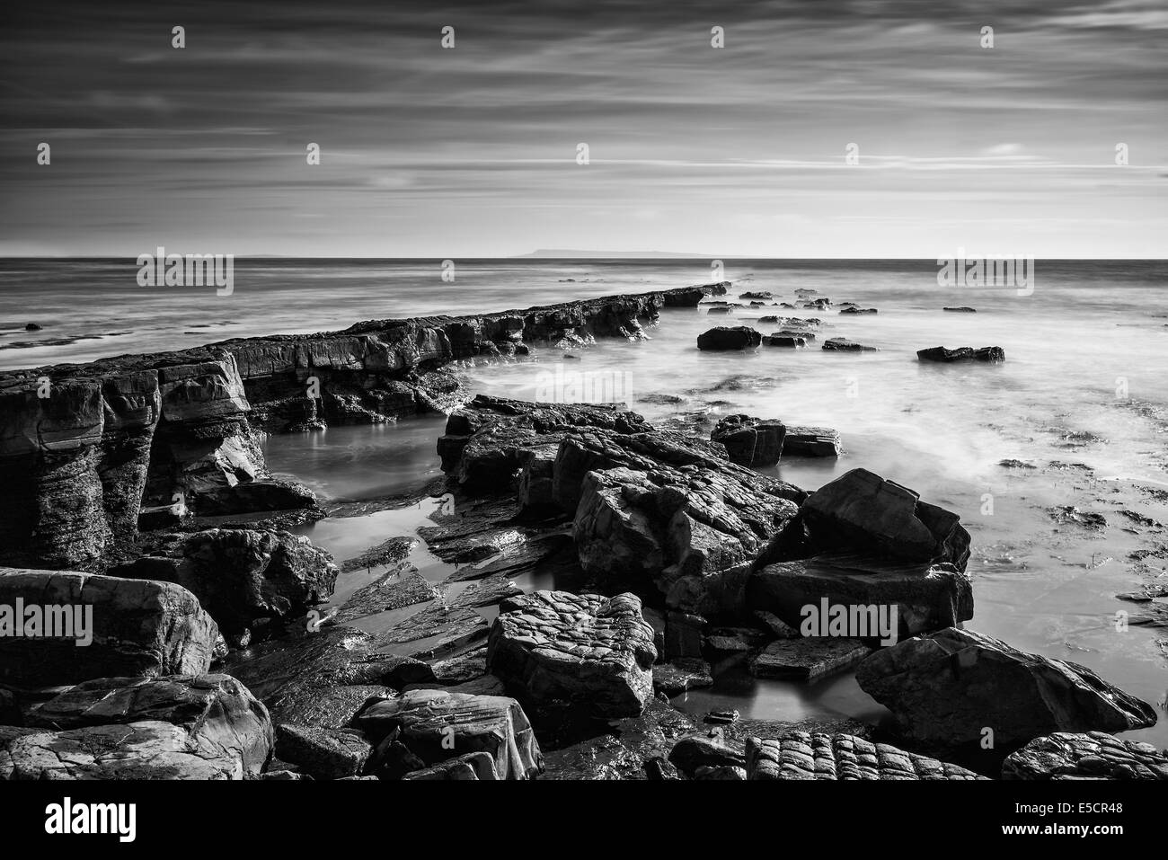 Atemberaubende Küste der schwarzen und weißen Seenlandschaft und felsige Ufer bei Sonnenuntergang Stockfoto