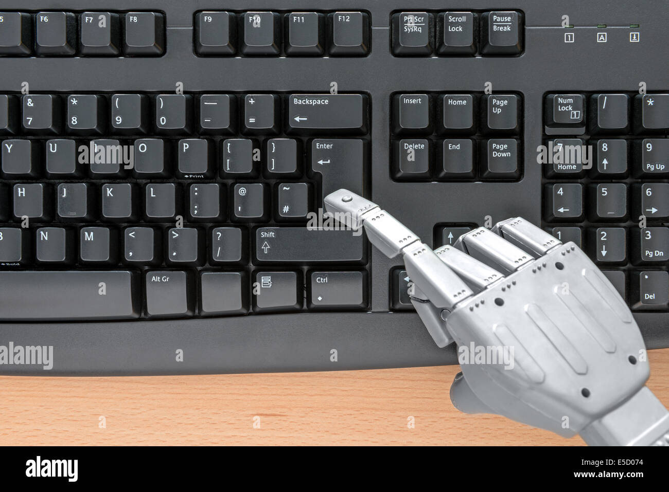 Roboterhand auf einer Computertastatur tippen. Stockfoto