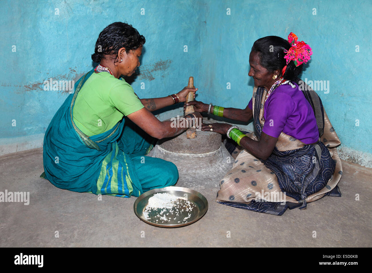 Stammesfrauen Mahlen von Reis, Baiga Stamm. Karangra Dorf, Chattisgadh, Indien Stockfoto