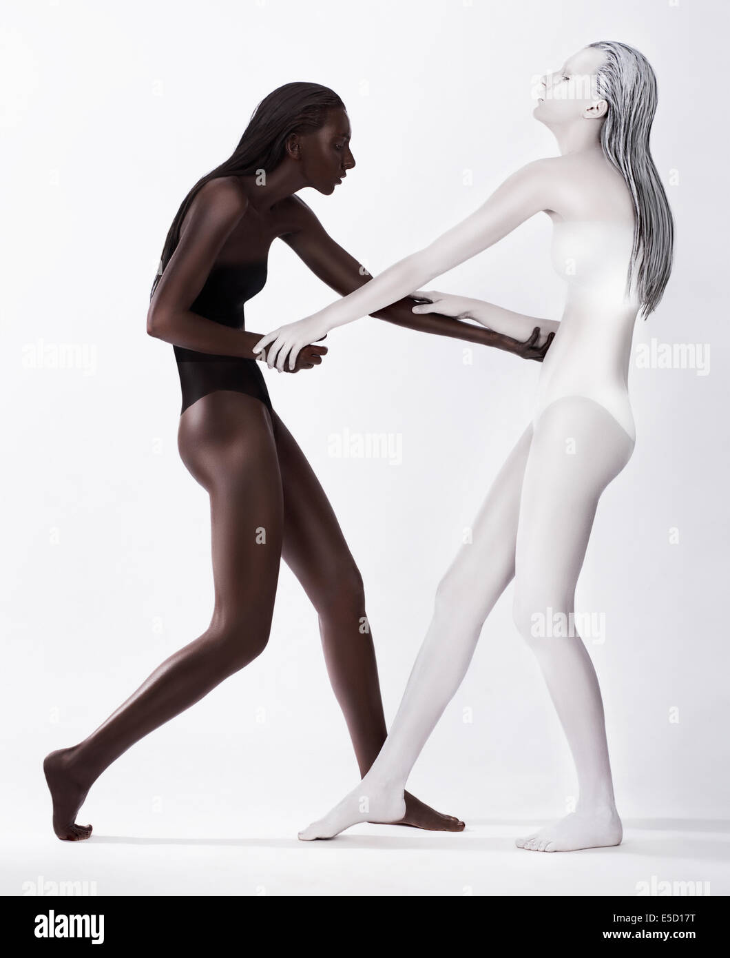 Zwei gestaltete rätselhafte Frauen farbige weiße und braune tanzen Stockfoto
