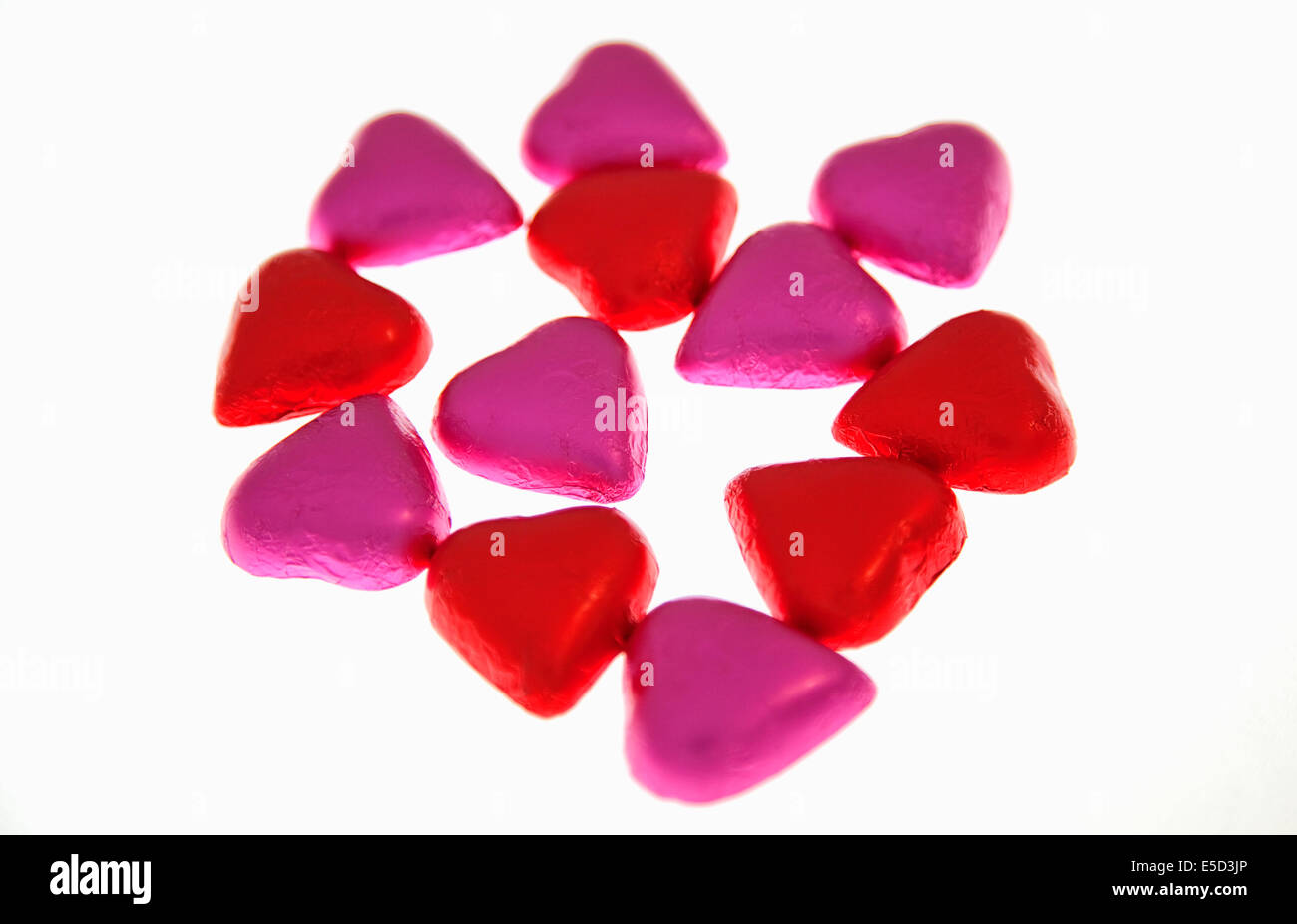 Lebensmittel, Süßwaren, Schokolade Herzen in rosa und rote farbige Folie abgedeckt. Stockfoto