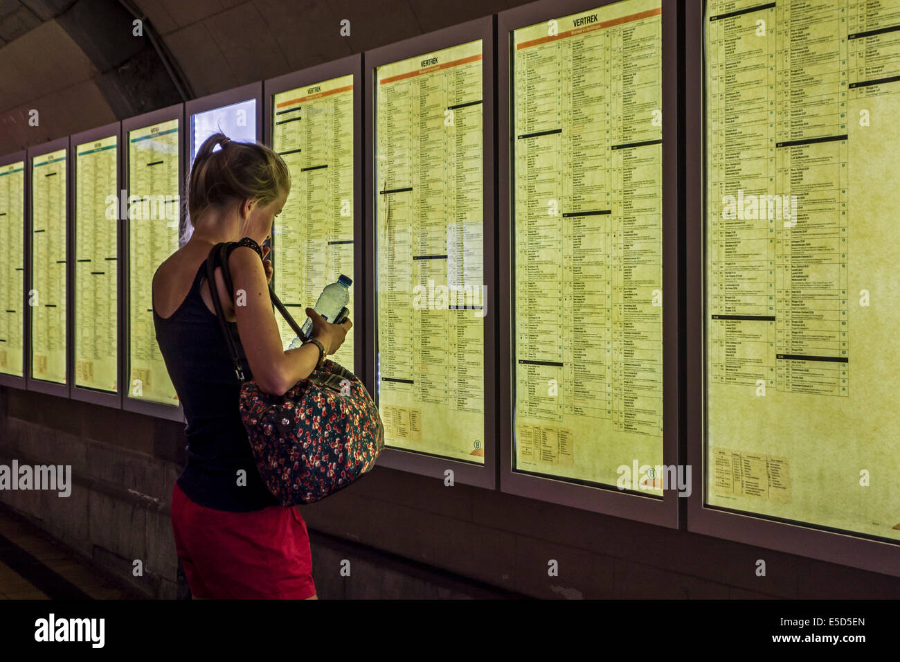 Reisende auf der Suche auf Stundenplan in Gent-Sint-Pieters / Sankt Peter Bahnhof in Gent, Ost-Flandern, Belgien Stockfoto