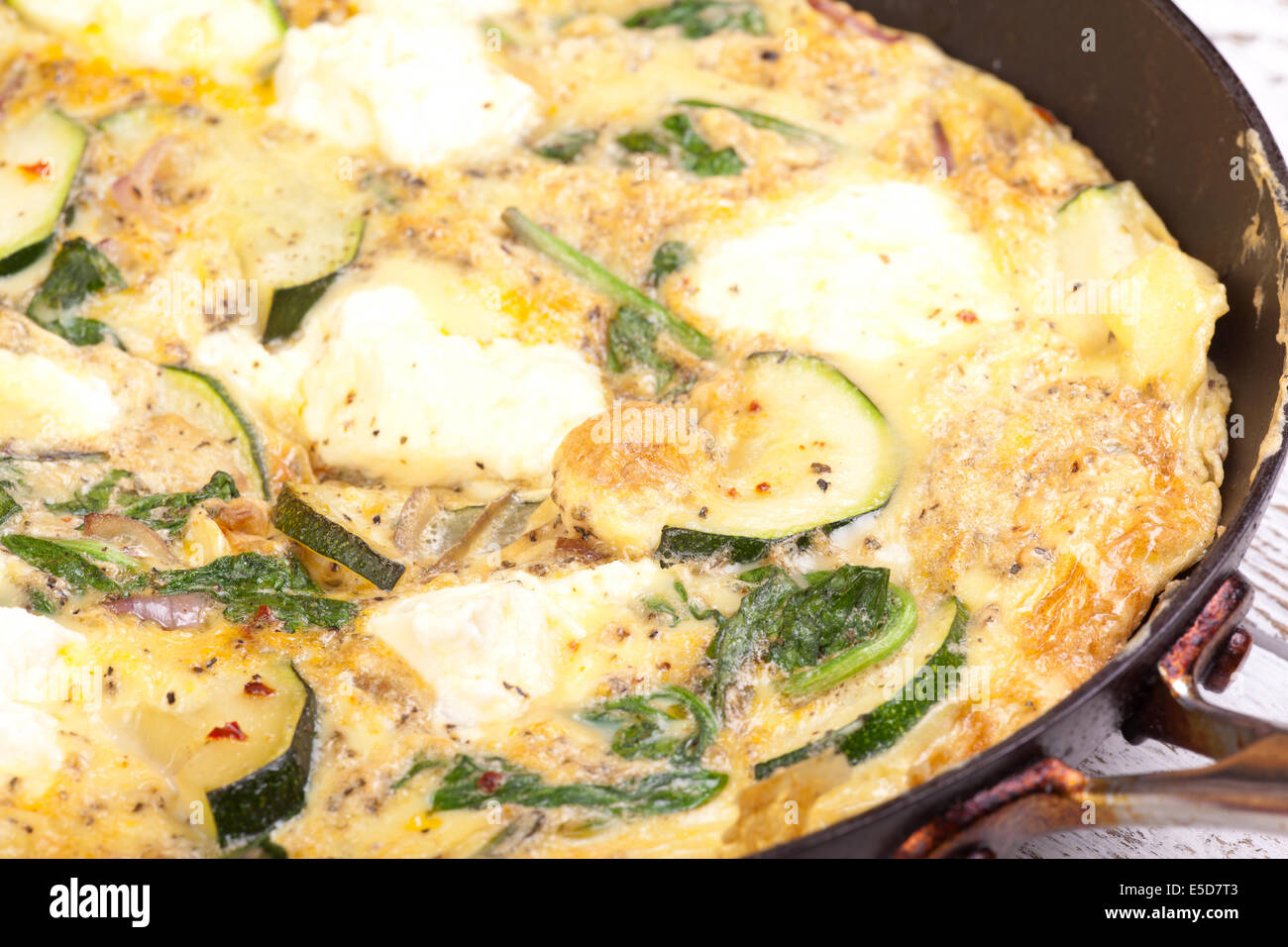 Zucchini, Spinat und Ricotta Käse Omelette in Pfanne Stockfoto