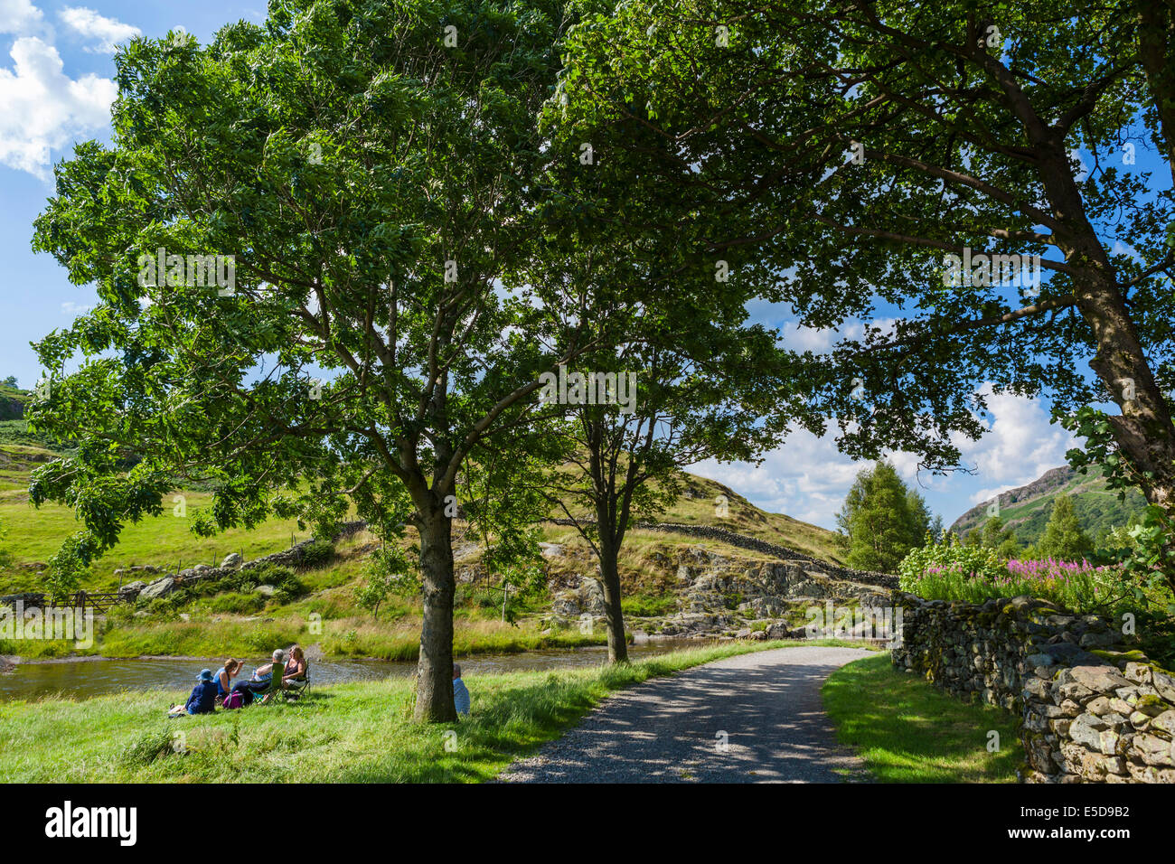 Menschen picknicken an der Seite des Watendlath Beck, Watendlath Tarn, Borrowdale, Lake District, England, UK Stockfoto