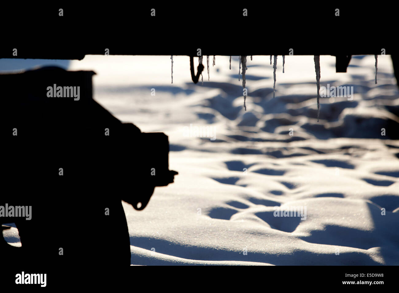 Eiszapfen unter LKW Schatten Schnee Fußabdrücke Stockfoto