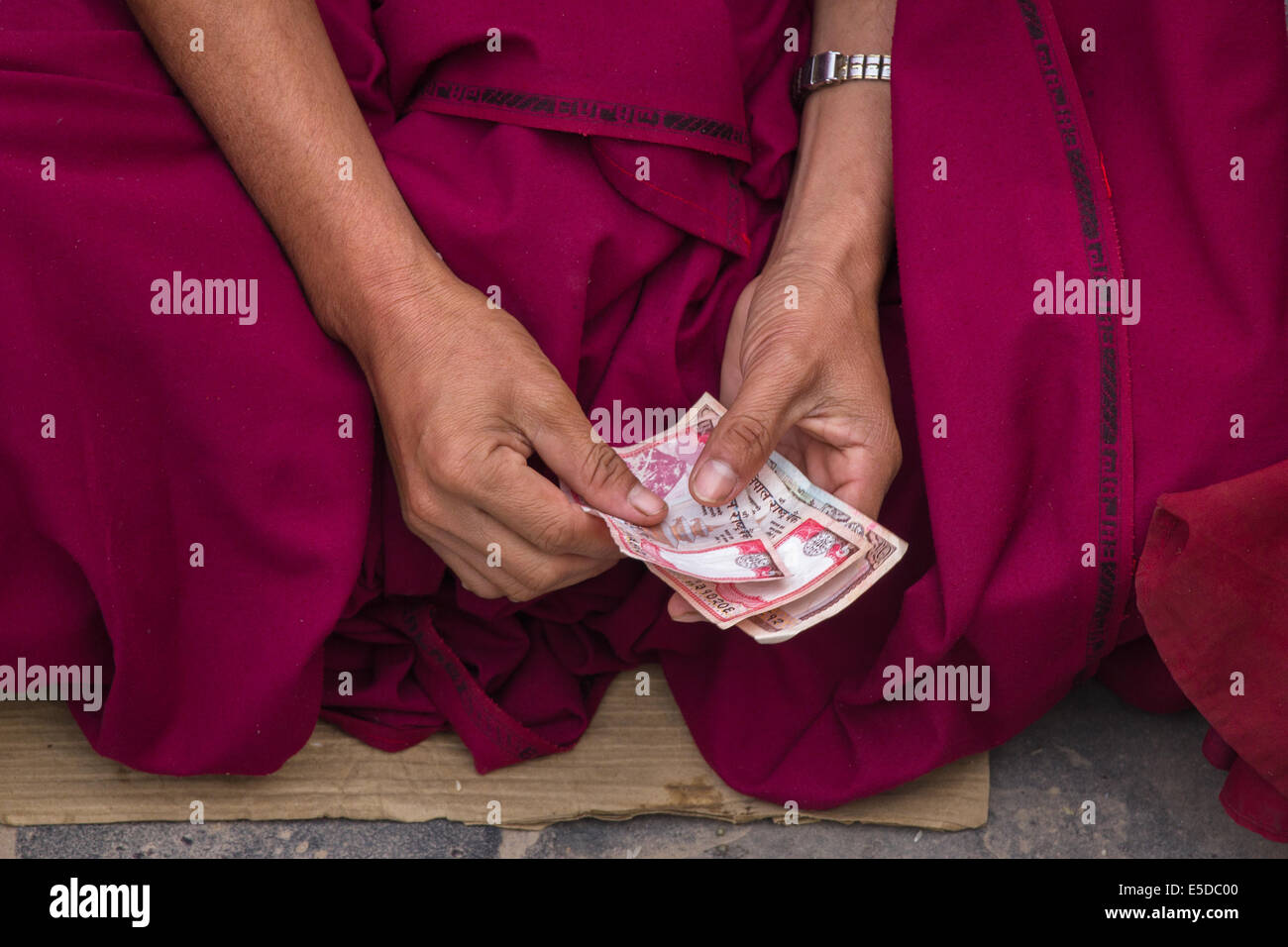 Die Hände von einem buddhistischen Mönch, zählen Geld erhielt als Almosen, in den frühen Morgenstunden an der buddhistischen Stupa von Bodnath (boudhanath), Kathmandu, Nepal. Stockfoto