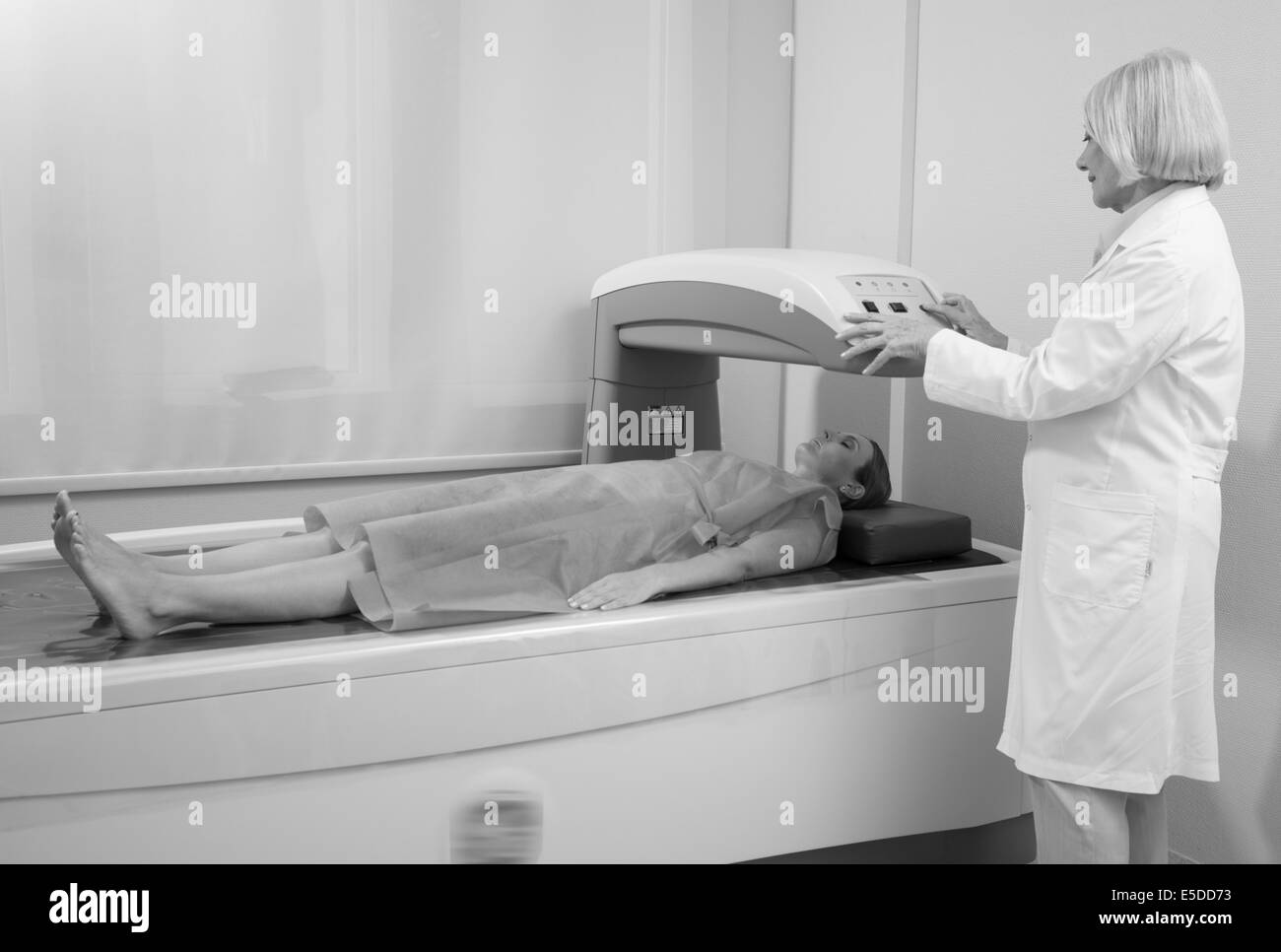 Frau in 40er Jahren Prüfung in Knochen Densitometer Maschine mit Reife Frau Arzt unterziehen. Stockfoto
