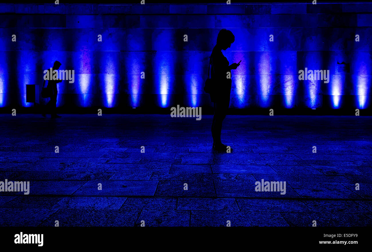 Silhouette, Frau mit Handy gegen blau beleuchtete Gebäude, Campus Westend, Goethe-Universität Frankfurt Stockfoto