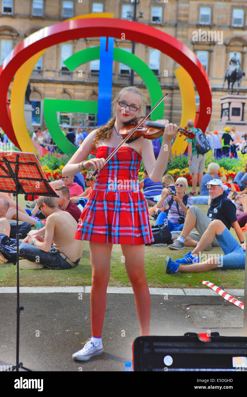 Glasgow, Schottland. 28. Juli 2014. Junges Mädchen trägt ein Kleid Tartan unterhält die Massen bei strahlendem Sonnenschein mit ihrer Violine spielen in George Square, Glasgow. Bildnachweis: PictureScotland/Alamy Live-Nachrichten Stockfoto
