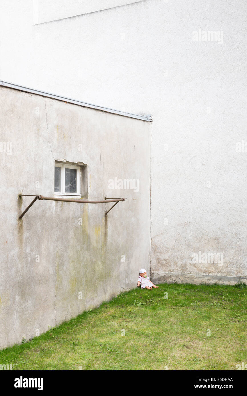Deutschland, glum Hinterhof mit Puppe aufgewirbelt auf Rasen in einer Ecke Stockfoto