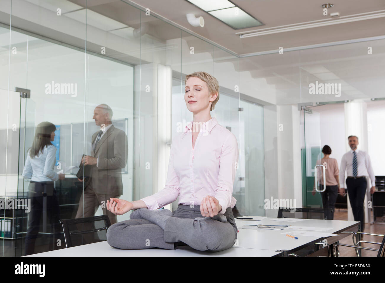 Deutschland, München, Geschäftsfrau im Büro, am Schreibtisch zu meditieren Stockfoto