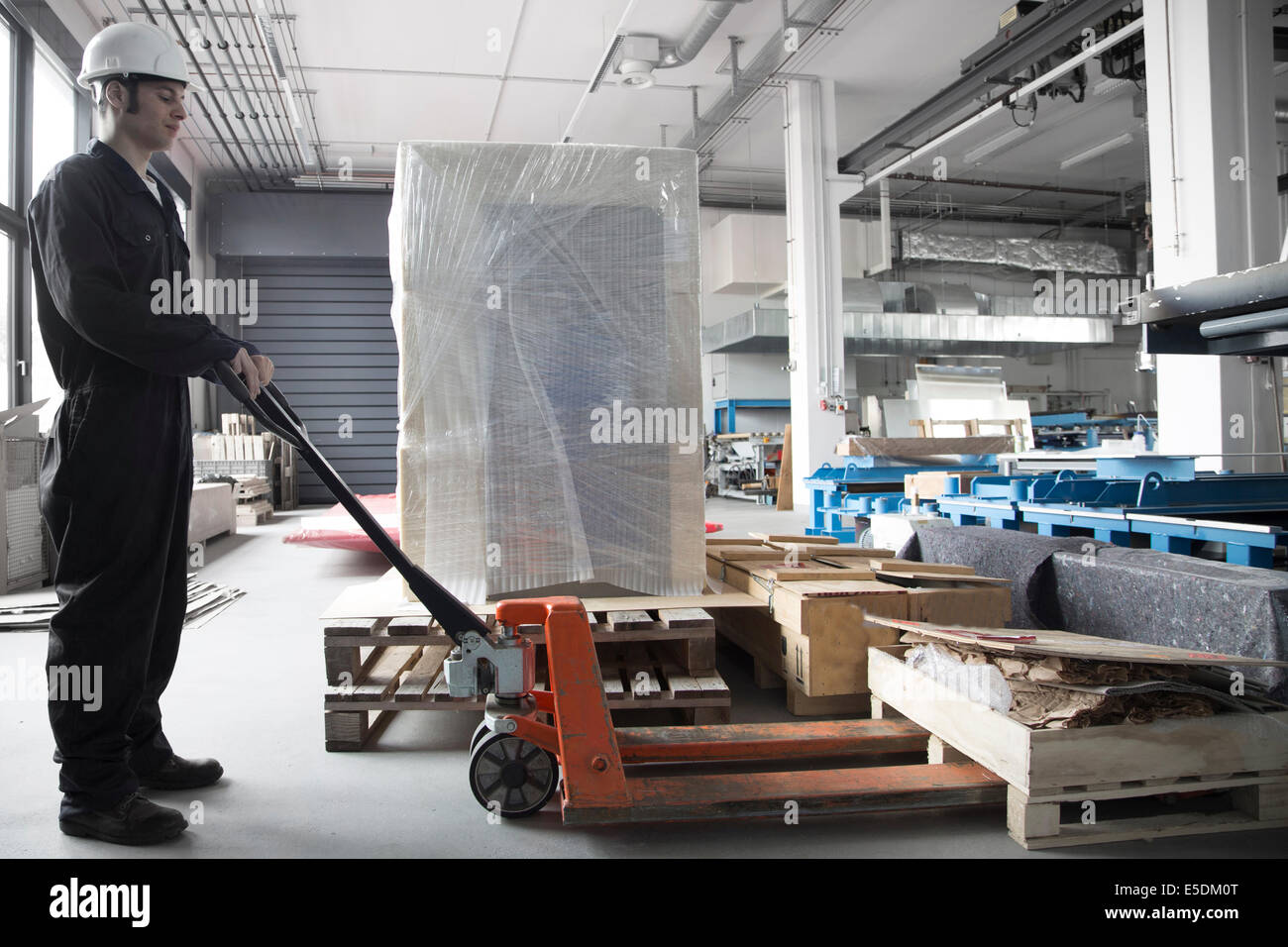 Arbeiter mit Hubwagen in einem Fabrikgebäude Stockfoto