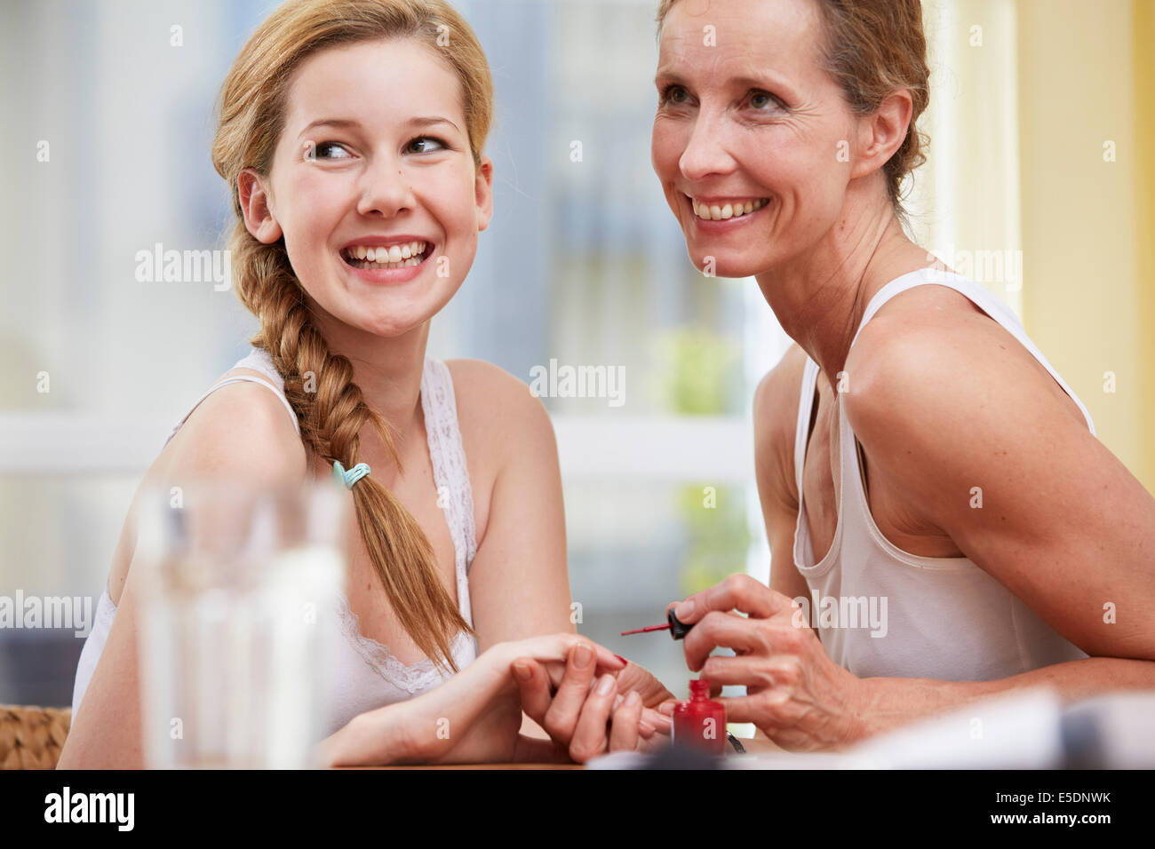 Lackieren der Nägel ihrer Tochter zu Hause Mutter Stockfoto