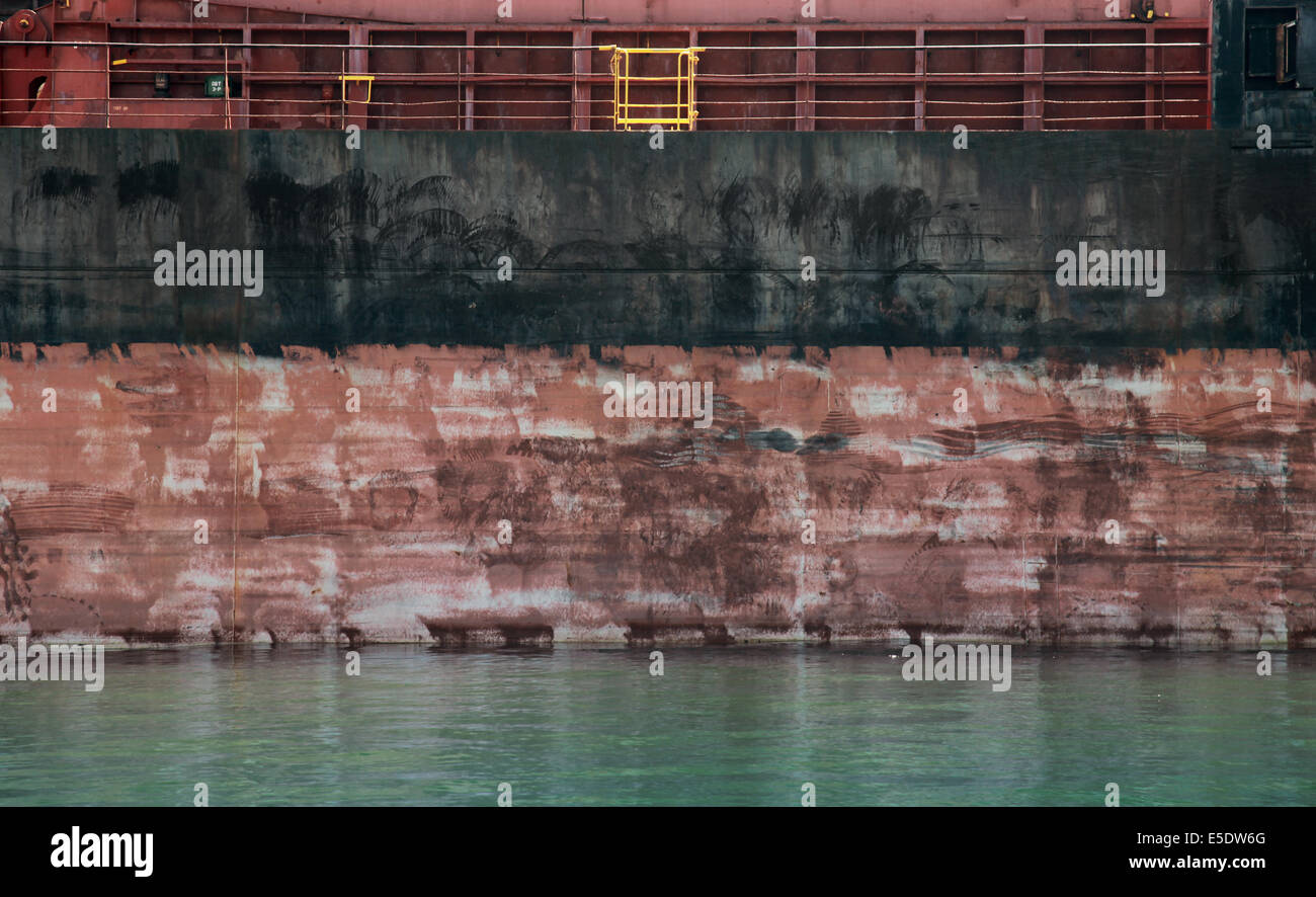 Schwarze und rote Cargo Schiffsrumpf Seite Textur und Wasser Stockfoto