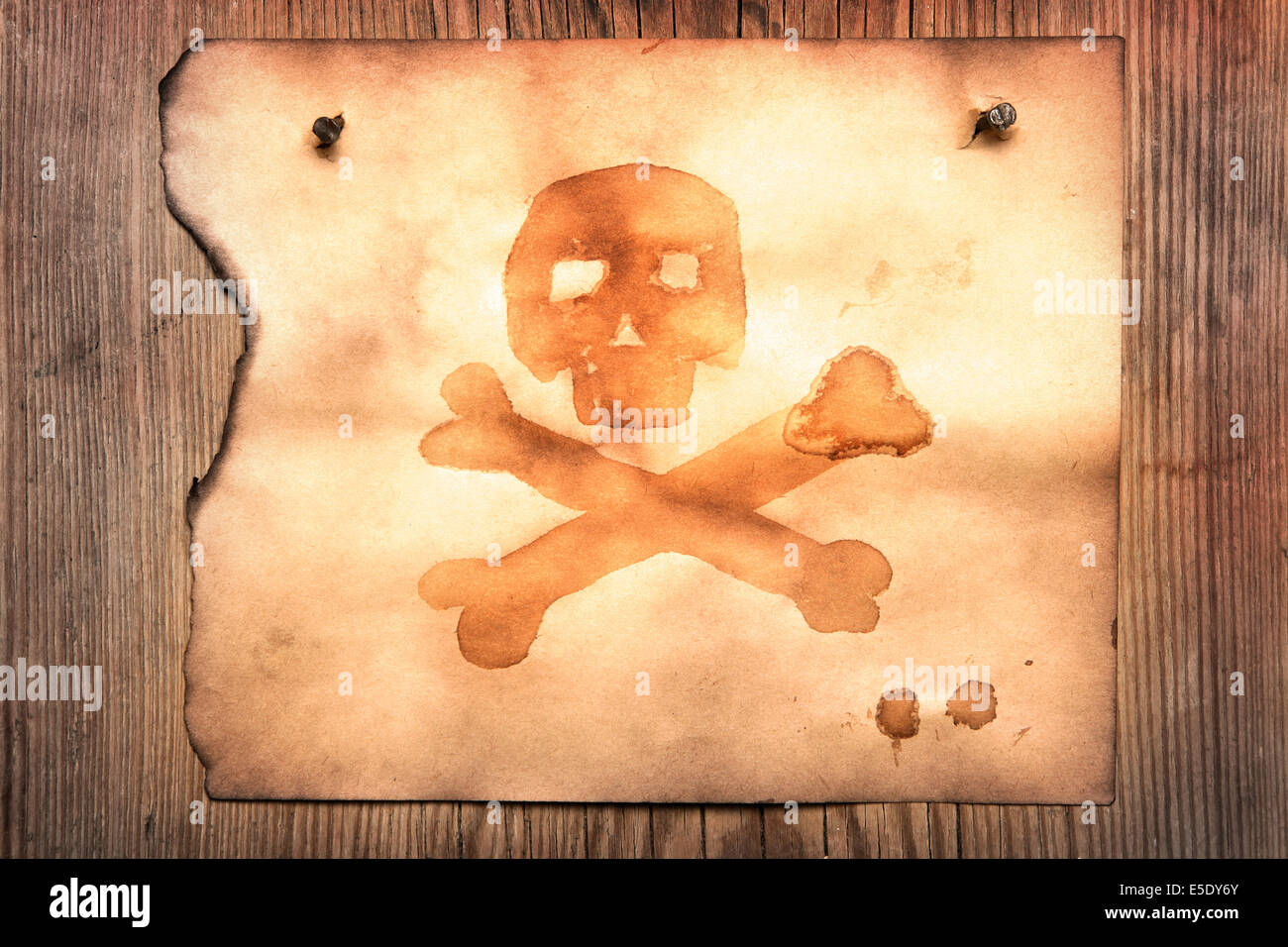 Altes Papier mit Jolly Roger an Holzwand befestigt Stockfoto