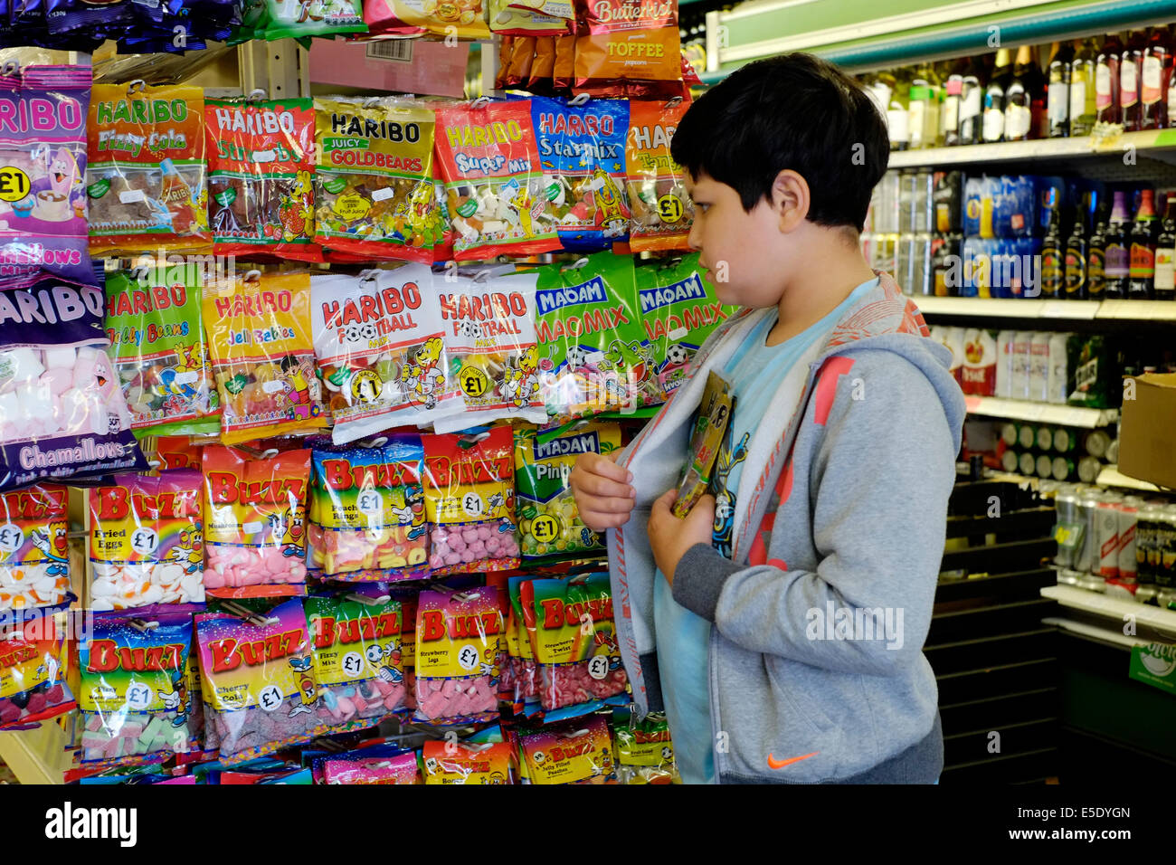 kleiner Junge Ladendiebstahl Süßigkeiten in einen kleinen Mini-Markt Stockfoto
