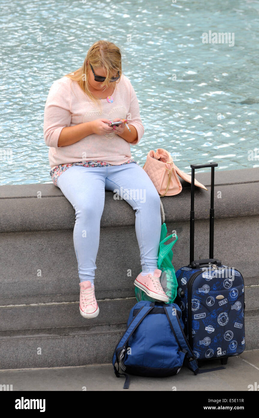 London, England, Vereinigtes Königreich. Trafalgar Square - übergewichtige Frau SMS und Rauchen Stockfoto