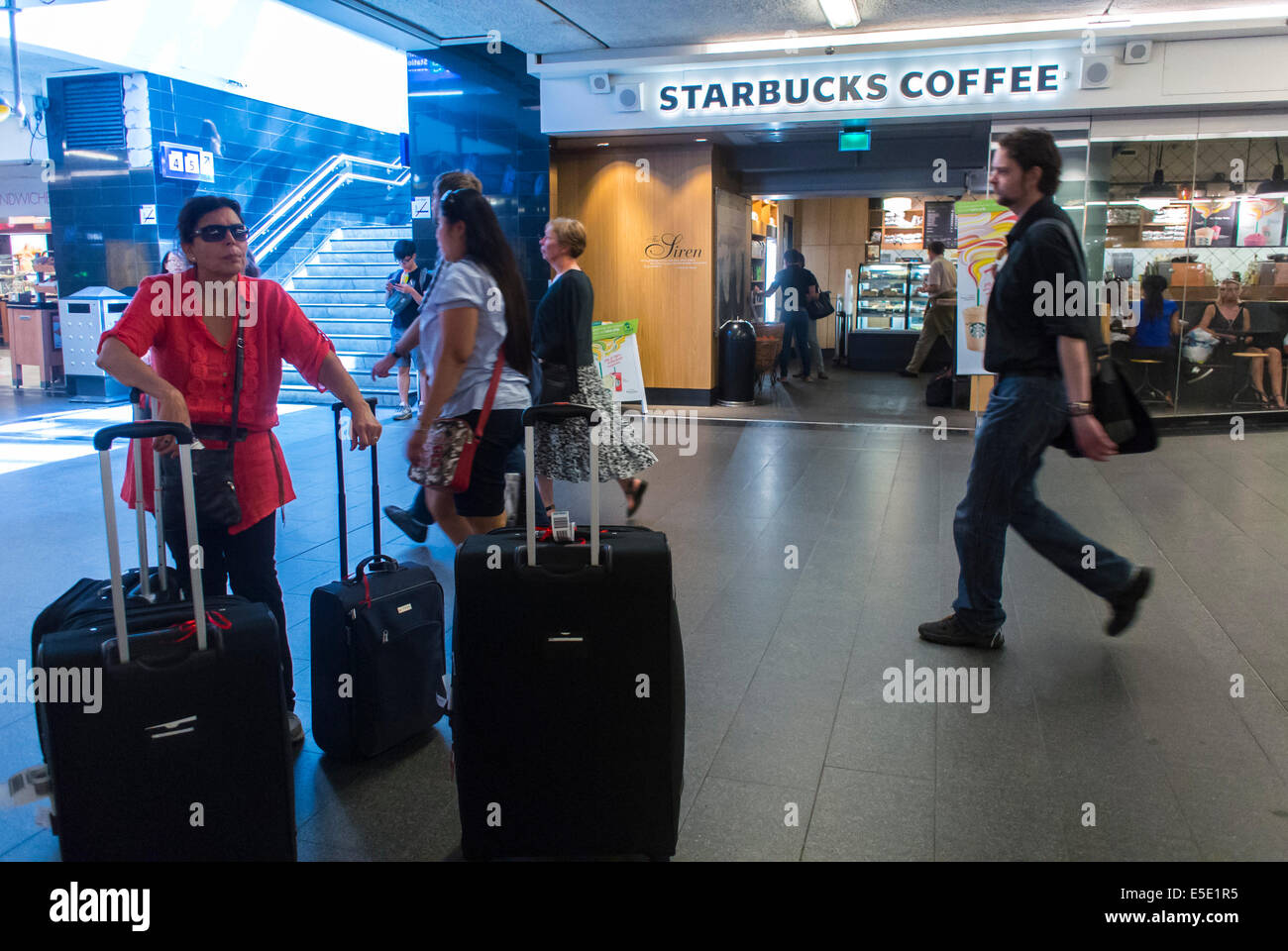 Amsterdam, Holland, Niederlande, Touristen mit Gepäck auf Rädern, im Hauptbahnhof, Personenkoffer, globale Zugfahrt Stockfoto