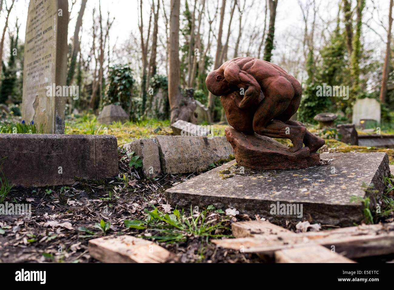 Skulptur eines Mannes schob ein Felsbrocken bergauf wie Sisyphos auf dem Highgate Cemetery. Stockfoto