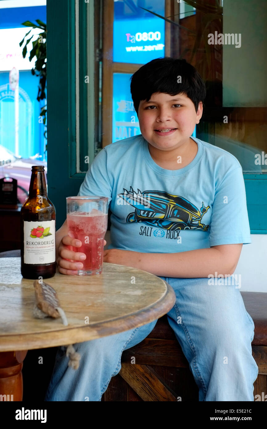 kleiner Junge saß im Pub auf der Suche nach seiner Väter Apfelwein trinken uk Stockfoto
