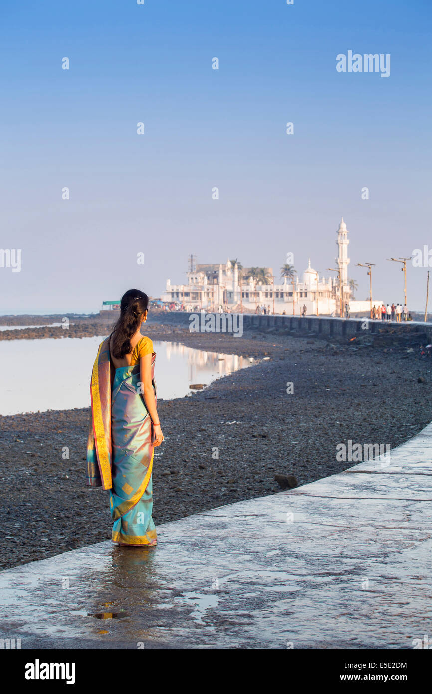 Eine junge Hinduistische Frau in einem blauen Sari auf dem Damm nach der Haji Ali Moschee, Mumbai, Maharashtra, Indien Stockfoto