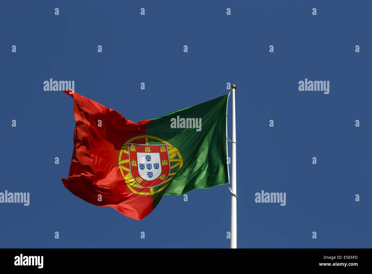 Portugiesische Nationalflagge vor einem strahlend blauen Himmel Stockfoto
