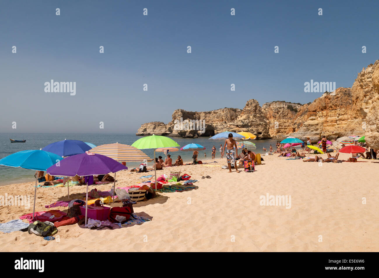 Menschen Sonnenbaden im Sommerurlaub auf Marinha Strand (Praia da Marinha), Algarve, Portugal Europa Stockfoto
