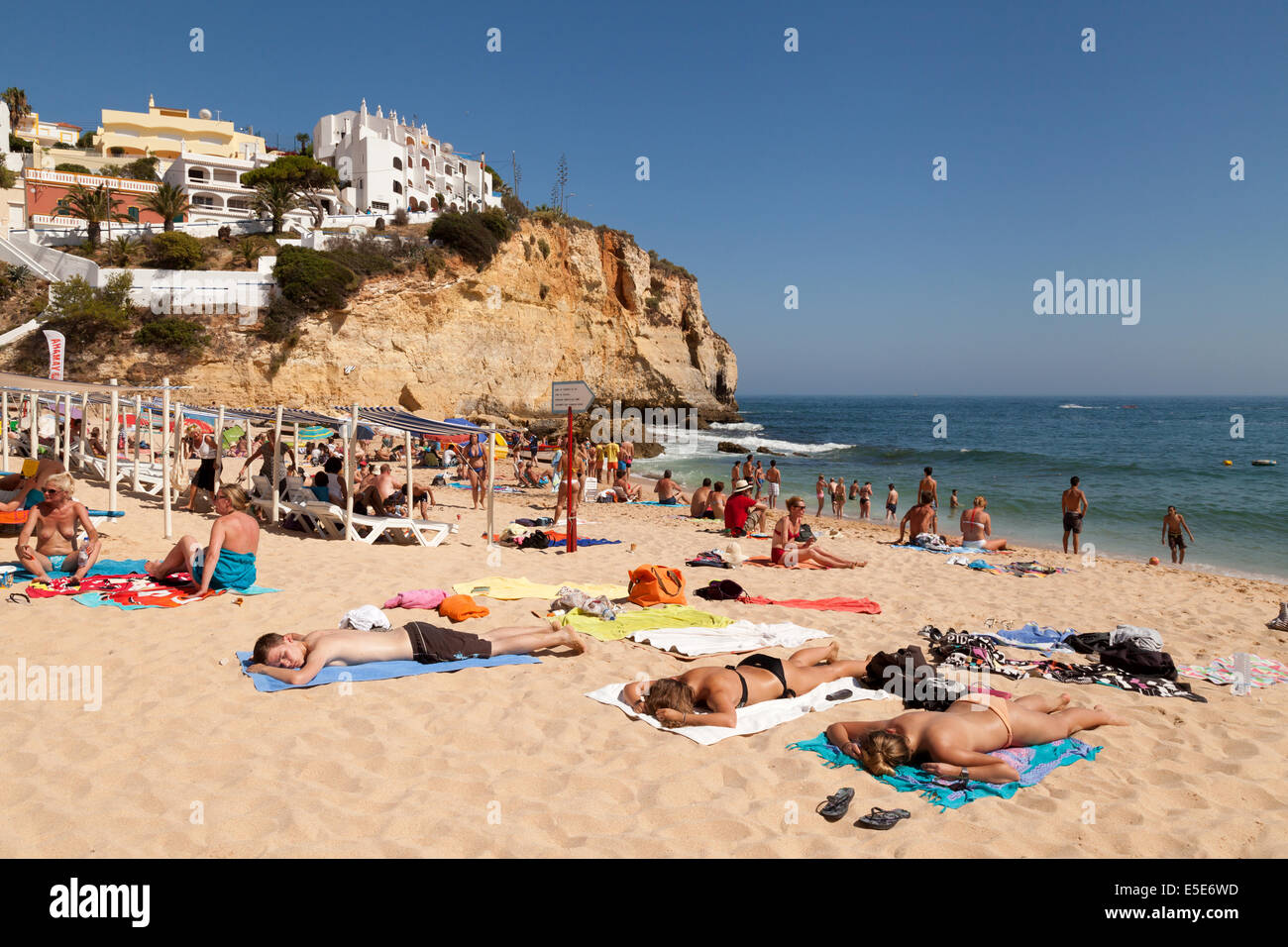 Menschen Sonnenbaden im Sommerurlaub am Strand von Carvoeiro, Algarve, Portugal Europa Stockfoto