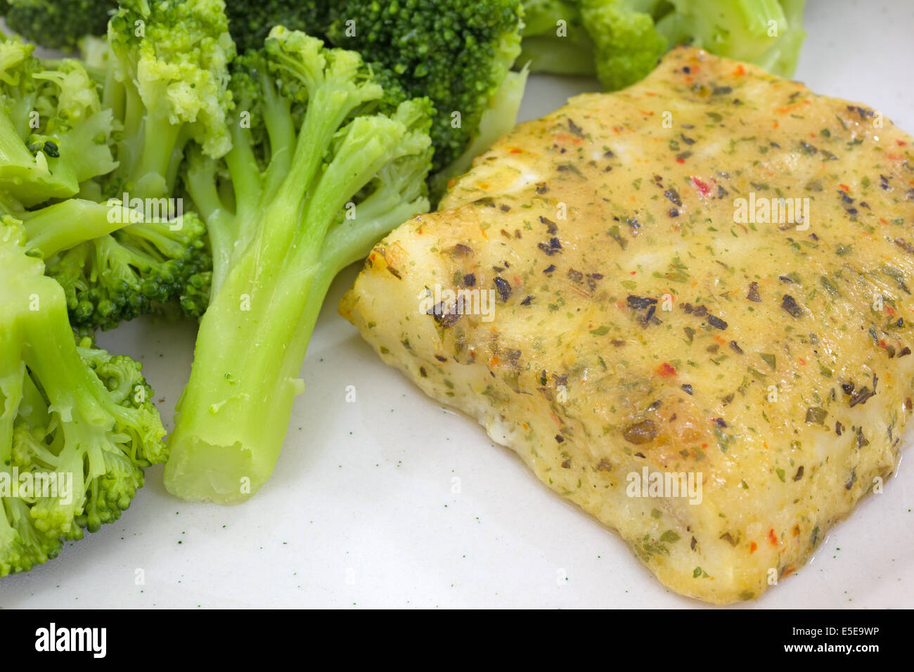 Nahaufnahme einer Kehlnaht gebackene Pollock auf einem Teller mit Brokkoli. Stockfoto