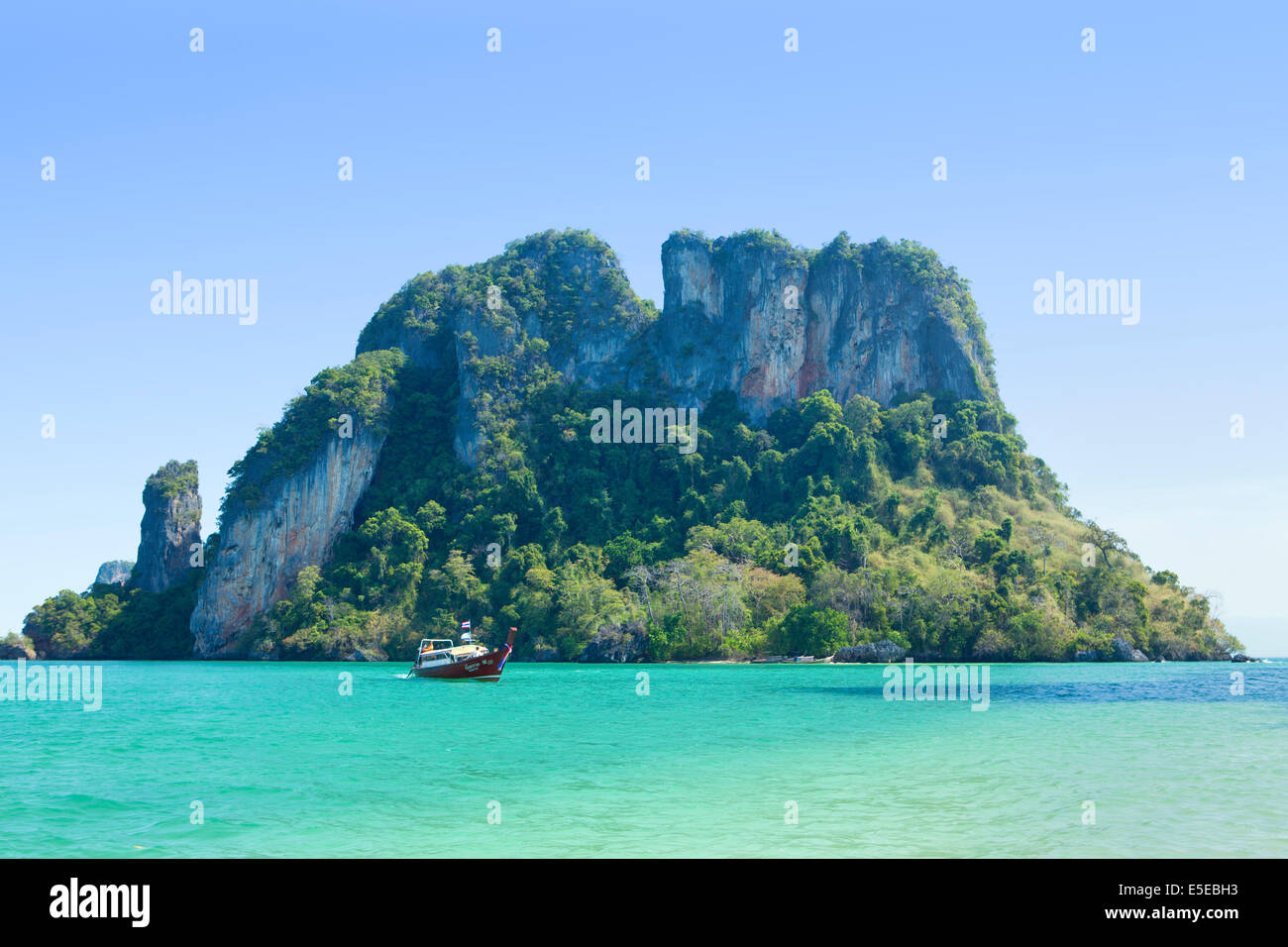 Thai Longtail-Boot vor einer felsigen Insel in der Nähe von Krabi, Thailand Stockfoto