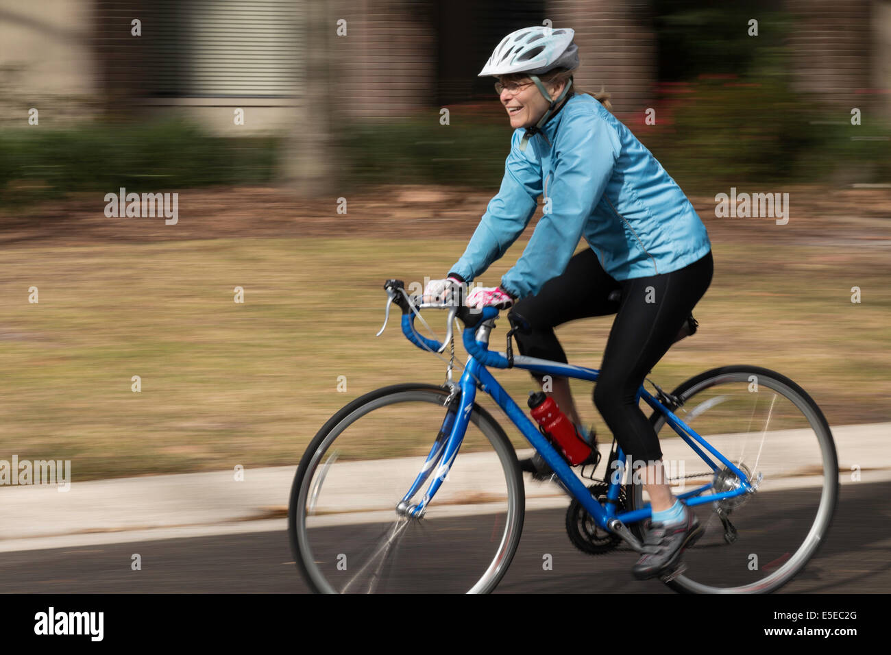 Reife Frau reitet ihr Fahrrad mit genehmigten Fangvorrichtung, USA Stockfoto