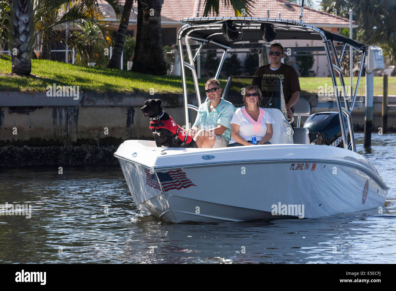 Ehepaar und Hund im Bug des Motorboot, Touring Kanäle, Punta Gorda, FL, USA Stockfoto