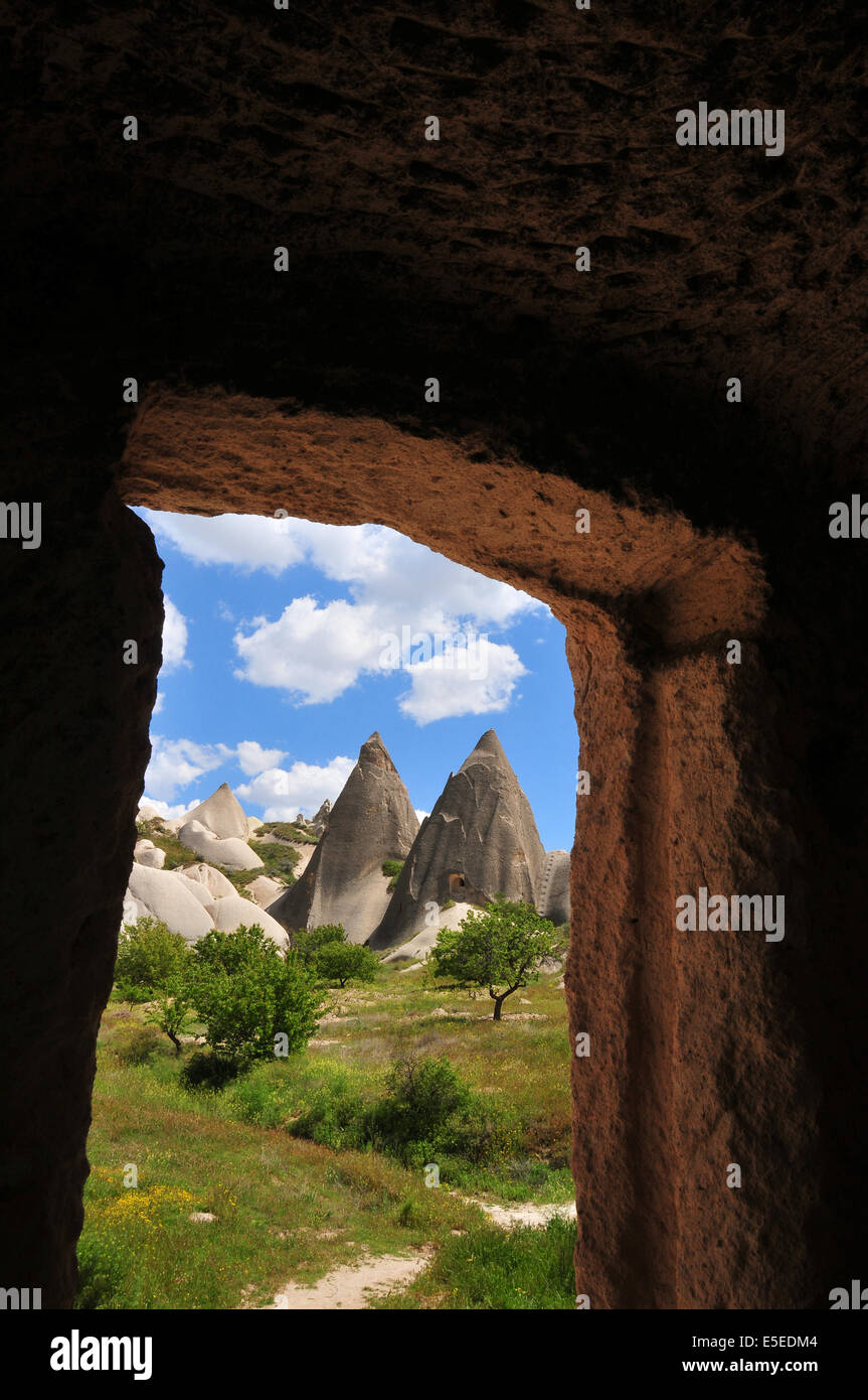 "Feenkamine" Felsformationen gesehen durch den Eingang einer Höhle Wohnung zwischen Ortahisar und Göreme in Kappadokien Stockfoto