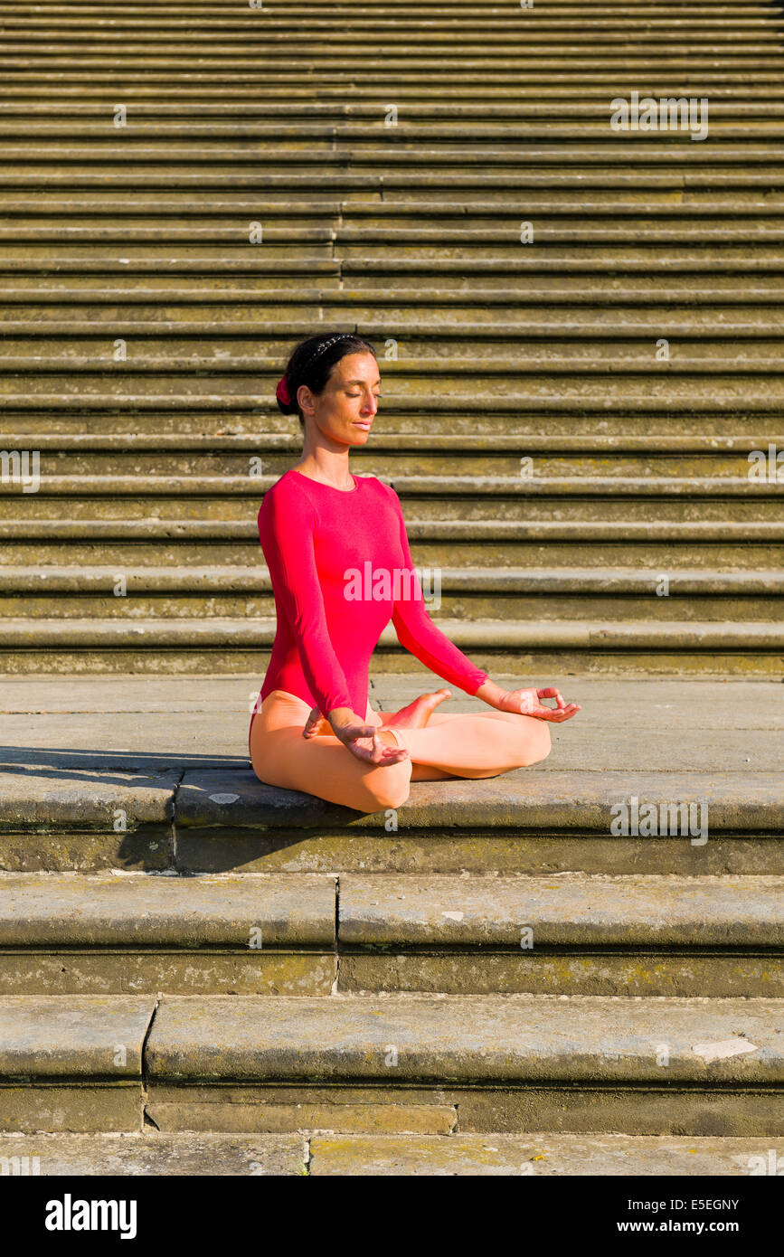 Junge Frau praktizieren Hatha-Yoga im Freien, hier die Pose Padmasana, Lotus pose Stockfoto