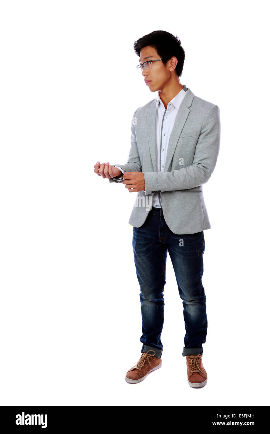 Voller Länge Porträt eines schönen asiatischen knöpfte seine Jacke auf weißem Hintergrund Stockfoto